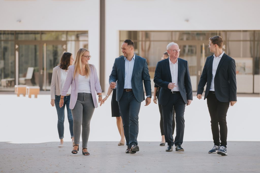 Mitarbeiter von Ludwig & Maldener gehen über den Platz vor der Kanzlei.
